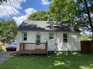 rear view of house with a wooden deck and driveway