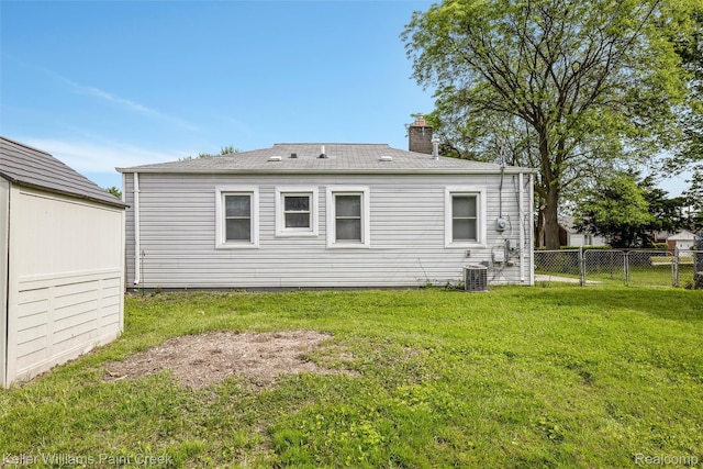 13350 Sidonie Ave, Warren, MI 48089 - rear view of house featuring central AC unit and a chimney