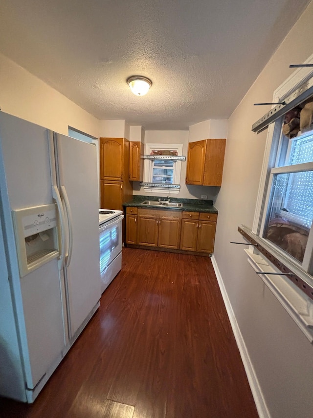18989 Washtenaw St, Harper Woods, MI 48225 - kitchen featuring white appliances, a sink, brown cabinets, dark wood-type flooring, and a textured ceiling