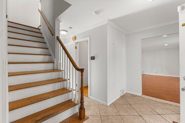 stairs featuring crown molding, tile patterned flooring, and baseboards