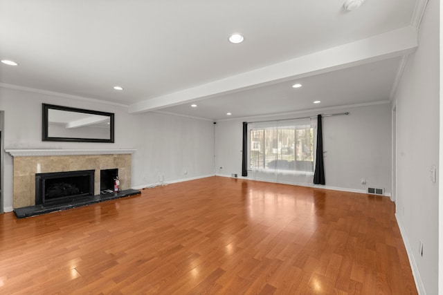 unfurnished living room with a high end fireplace, light wood-style flooring, crown molding, recessed lighting, and baseboards