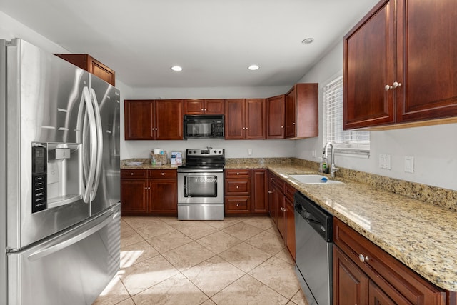 kitchen featuring appliances with stainless steel finishes, a sink, recessed lighting, light stone countertops, and light tile patterned floors