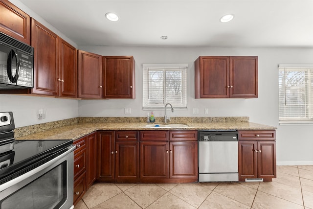 kitchen featuring stainless steel appliances, a sink, healthy amount of natural light, light tile patterned floors, and recessed lighting