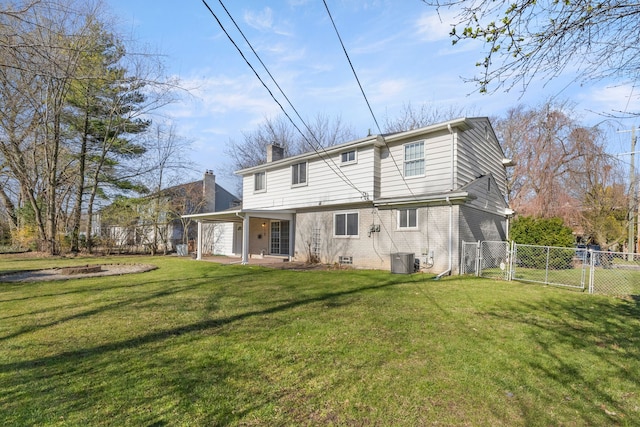back of house featuring a gate, a chimney, brick siding, and central AC