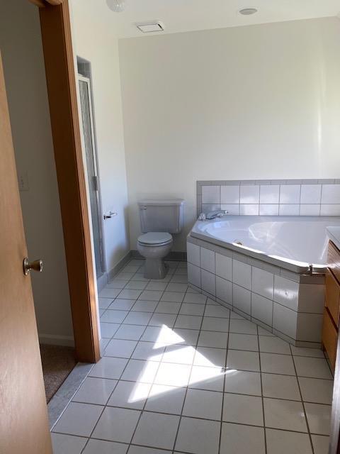 28379 Emerald Ct, Chesterfield, MI 48047 - bathroom featuring tile patterned floors, toilet, a garden tub, baseboards, and a shower with shower door