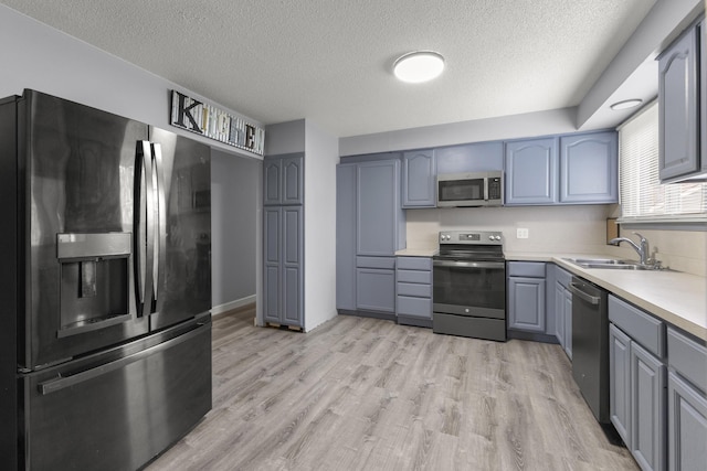 12550 Devoe St, Southgate, MI 48195 - kitchen with appliances with stainless steel finishes, a sink, gray cabinets, a textured ceiling, and light countertops