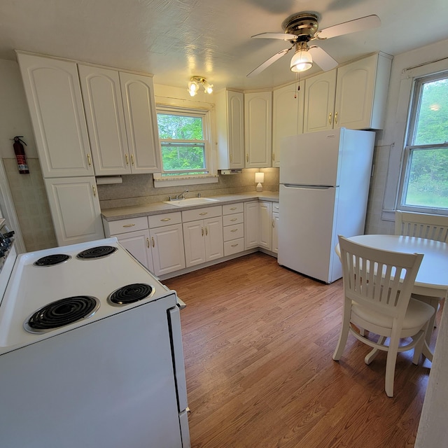 1614 Mooreville Rd, Milan, MI 48160 - kitchen featuring white appliances, a sink, light wood finished floors, light countertops, and white cabinetry