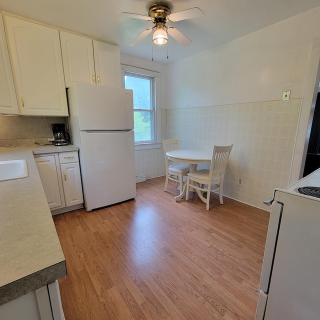 1614 Mooreville Rd, Milan, MI 48160 - kitchen with freestanding refrigerator, range, light wood finished floors, ceiling fan, and white cabinetry