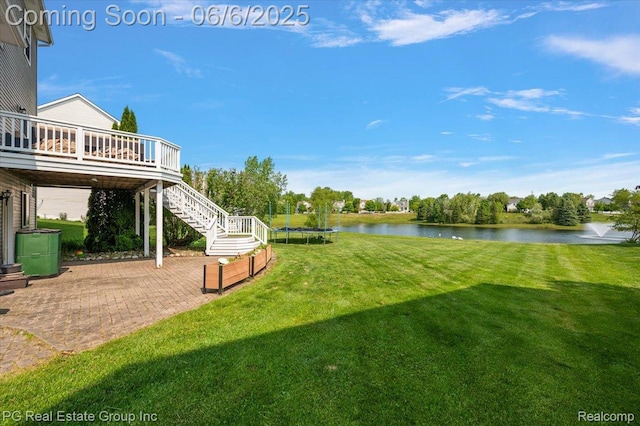 1226 Fountain View Ln, Oxford, MI 48371 - view of green lawn featuring a trampoline, stairs, a patio, and a deck with water view