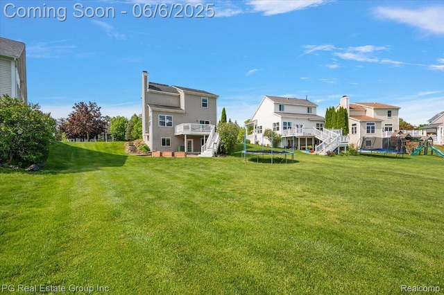 1226 Fountain View Ln, Oxford, MI 48371 - view of grassy yard featuring a trampoline, stairs, a wooden deck, and a playground