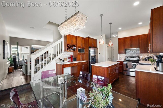 1226 Fountain View Ln, Oxford, MI 48371 - kitchen featuring appliances with stainless steel finishes, a sink, a center island, backsplash, and light countertops