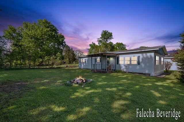 914 32nd St, Allegan, MI 49010 - back of house featuring a yard and an outdoor fire pit