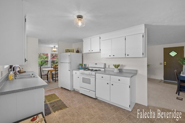 914 32nd St, Allegan, MI 49010 - kitchen with white appliances, a sink, white cabinetry, light countertops, and a textured ceiling