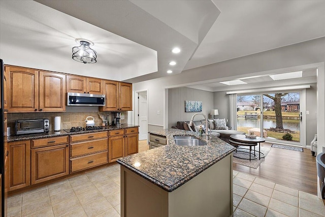53383 Starlite Dr, Michigan, MI 48316 - kitchen featuring a sink, stainless steel microwave, brown cabinetry, open floor plan, and recessed lighting