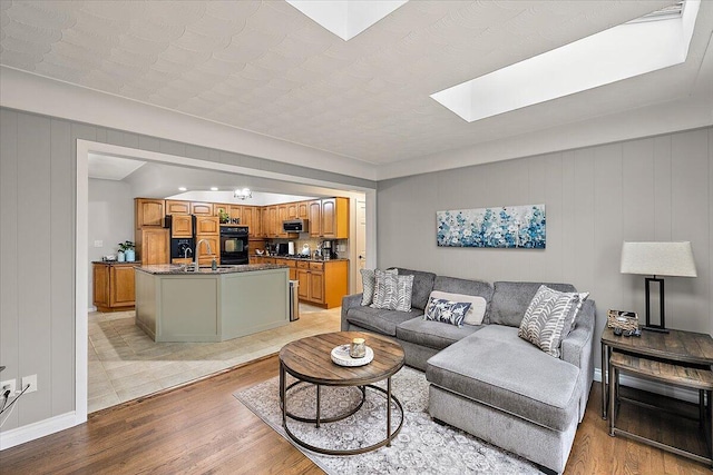 53383 Starlite Dr, Michigan, MI 48316 - living room with a skylight, light wood-style floors, and baseboards