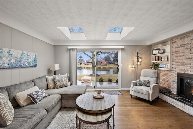 53383 Starlite Dr, Michigan, MI 48316 - living room featuring a skylight, wood finished floors, a fireplace, a water view, and a textured ceiling
