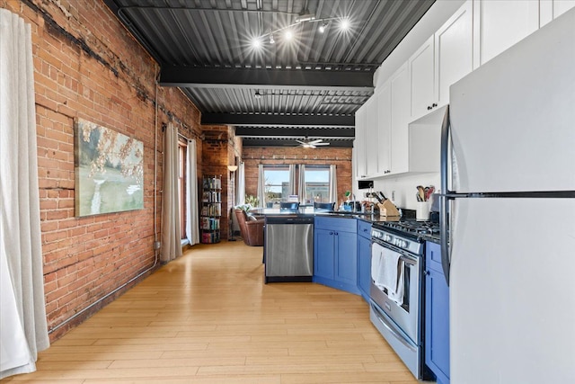 112 Watson St Unit 28, Detroit, MI 48201 - kitchen with stainless steel appliances, brick wall, blue cabinets, white cabinetry, and light wood-type flooring