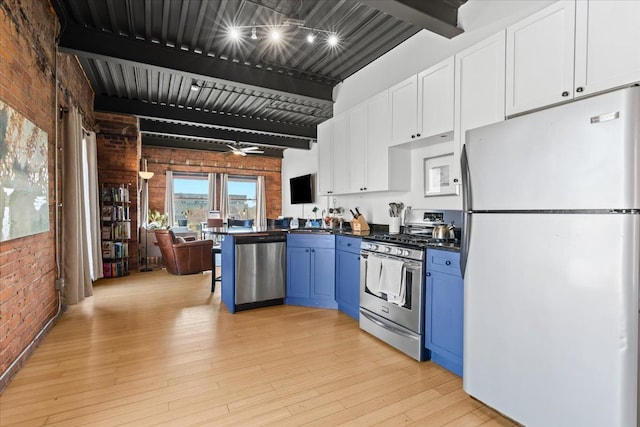 112 Watson St Unit 28, Detroit, MI 48201 - kitchen featuring appliances with stainless steel finishes, brick wall, dark countertops, beam ceiling, and blue cabinetry