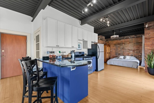 112 Watson St Unit 28, Detroit, MI 48201 - kitchen featuring appliances with stainless steel finishes, beamed ceiling, white cabinets, a kitchen breakfast bar, and a sink