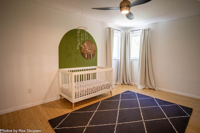 2490 S Parsons Ave, Fremont, MI 49412 - unfurnished bedroom featuring wood finished floors, a crib, and baseboards