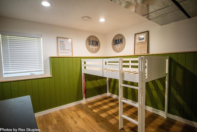 2490 S Parsons Ave, Fremont, MI 49412 - unfurnished bedroom featuring wood finished floors, wainscoting, wooden walls, and recessed lighting