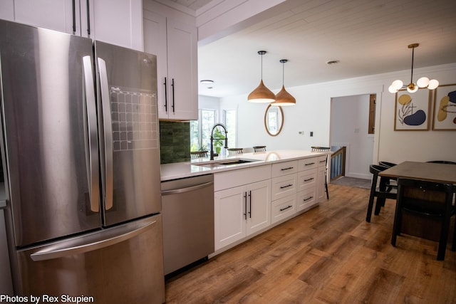 2490 S Parsons Ave, Fremont, MI 49412 - kitchen with appliances with stainless steel finishes, a sink, wood finished floors, white cabinetry, and light countertops