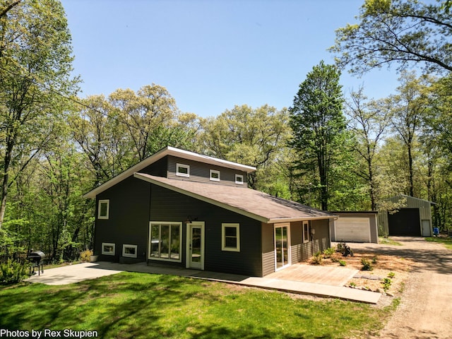 2490 S Parsons Ave, Fremont, MI 49412 - mid-century modern home with an outbuilding, a front lawn, driveway, a garage, and a patio