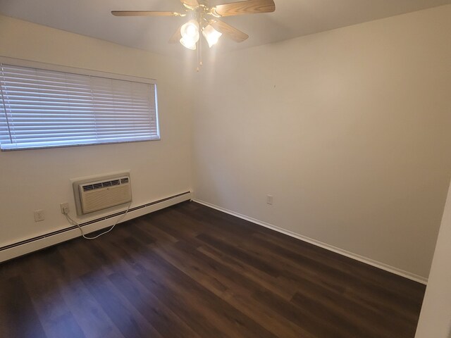 417 Prospect Unit # 210, Romeo, MI 48065 - empty room with baseboard heating, dark wood-style flooring, a ceiling fan, a wall mounted AC, and baseboards