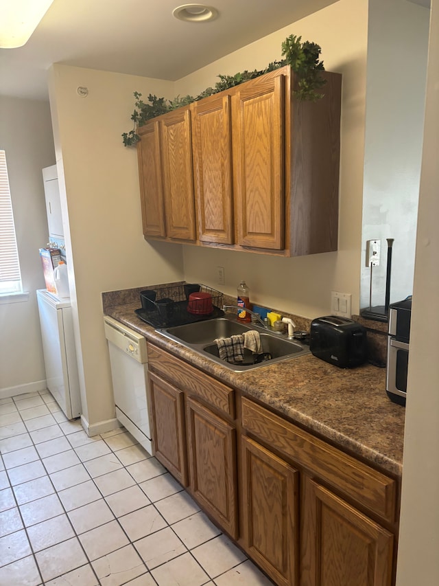 836 Brandon Ave, Pontiac, MI 48340 - kitchen with dishwasher, washer / dryer, light tile patterned floors, dark countertops, and a sink