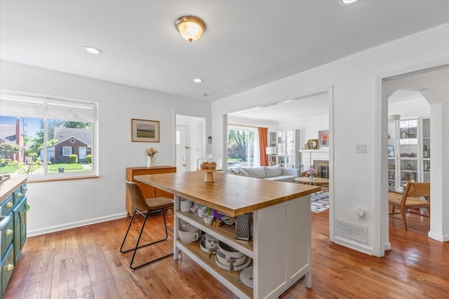 21111 Fleetwood Dr, Harper Woods, MI 48225 - kitchen featuring butcher block counters, healthy amount of natural light, light wood finished floors, arched walkways, and recessed lighting