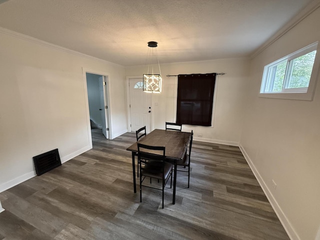 dining room featuring dark wood finished floors, baseboards, and crown molding