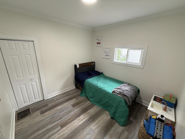 bedroom featuring wood finished floors, ornamental molding, and baseboards