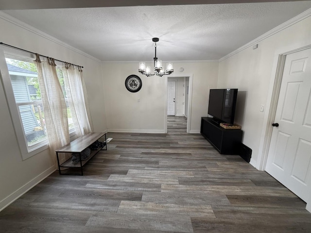 unfurnished dining area featuring a chandelier, wood finished floors, ornamental molding, baseboards, and a textured ceiling