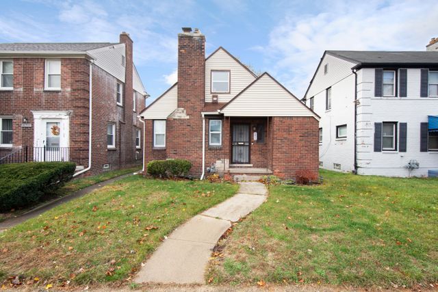 18711 Indiana St, Detroit, MI 48221 - view of front of property featuring brick siding, a front lawn, and a chimney