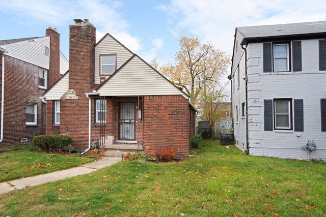 18711 Indiana St, Detroit, MI 48221 - view of front of house with a front yard, brick siding, and a chimney