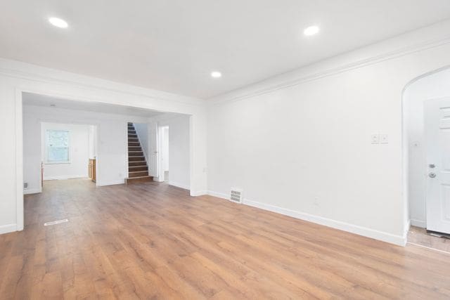 18711 Indiana St, Detroit, MI 48221 - spare room with stairs, light wood-type flooring, recessed lighting, baseboards, and crown molding