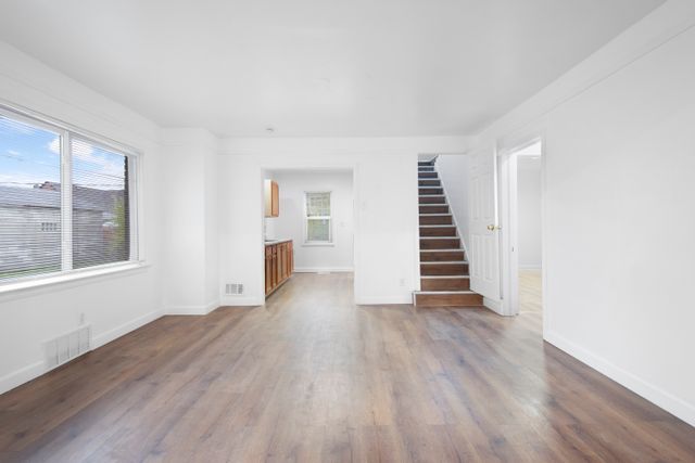 18711 Indiana St, Detroit, MI 48221 - unfurnished living room with stairway, wood finished floors, and baseboards
