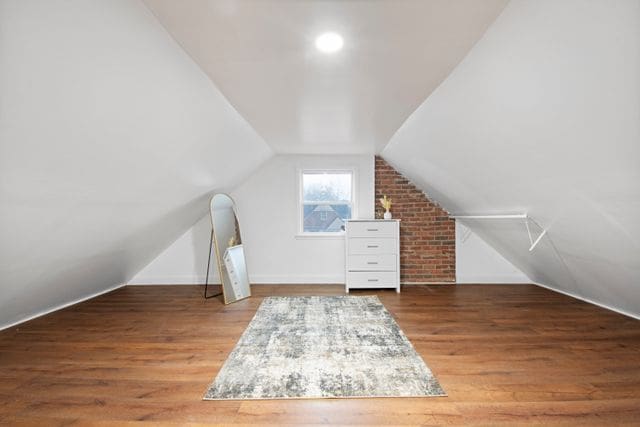 18711 Indiana St, Detroit, MI 48221 - additional living space with lofted ceiling, wood finished floors, and baseboards