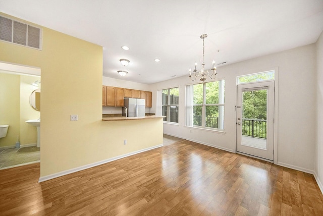 3197 Asher Rd, Ann Arbor, MI 48104 - kitchen with freestanding refrigerator, a chandelier, wood finished floors, baseboards, and recessed lighting