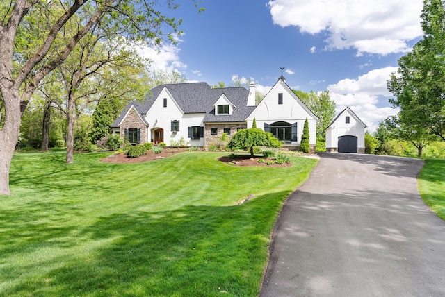4263 Windmill Farms, Milford, MI 48380 - view of front of house with an outdoor structure, a chimney, a front lawn, and asphalt driveway