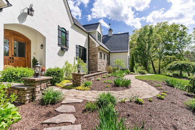 4263 Windmill Farms, Milford, MI 48380 - view of home's exterior featuring stucco siding, a shingled roof, stone siding, and a chimney