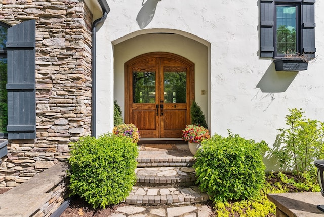 4263 Windmill Farms, Milford, MI 48380 - doorway to property featuring french doors, stone siding, and stucco siding