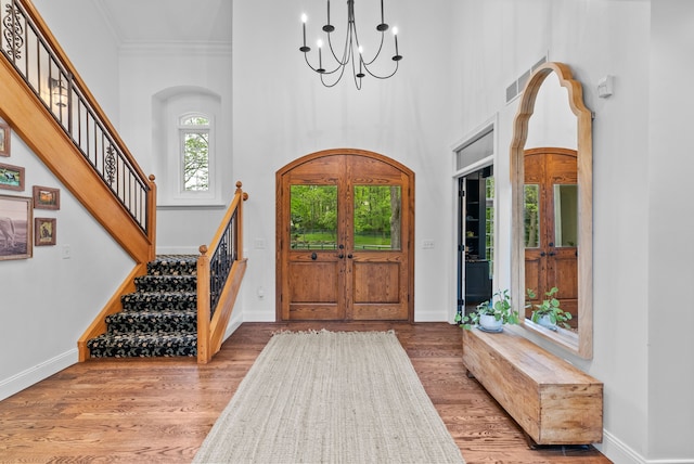 4263 Windmill Farms, Milford, MI 48380 - foyer featuring a chandelier, wood finished floors, ornamental molding, stairs, and a high ceiling