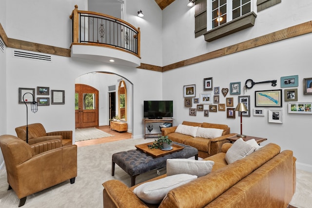 4263 Windmill Farms, Milford, MI 48380 - carpeted living area with arched walkways, a high ceiling, and baseboards