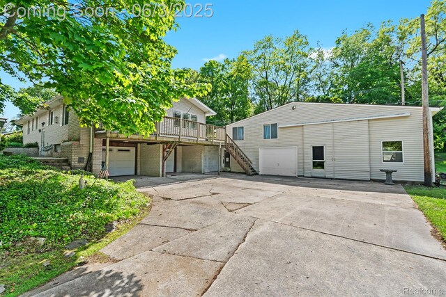 7109 Lake Shore Dr, Chelsea, MI 48118 - view of front of house with a garage, stairway, driveway, and brick siding
