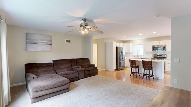 1670 Edwin Dr, Brighton, MI 48114 - living room with a ceiling fan, light wood-style flooring, recessed lighting, baseboards, and light colored carpet