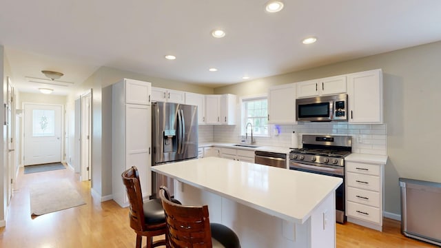 1670 Edwin Dr, Brighton, MI 48114 - kitchen featuring appliances with stainless steel finishes, a sink, a kitchen bar, tasteful backsplash, and recessed lighting