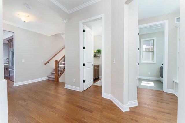 10408 Stoney Point Dr, South Lyon, MI 48178 - corridor with wood finished floors, stairs, ornamental molding, baseboards, and washer / dryer
