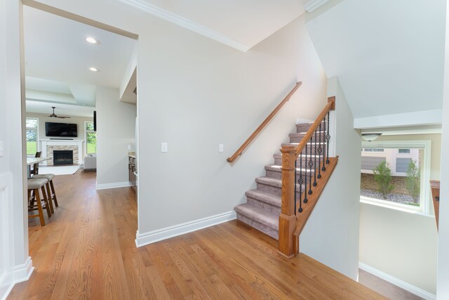 10408 Stoney Point Dr, South Lyon, MI 48178 - stairway with wood finished floors, a fireplace, baseboards, ornamental molding, and recessed lighting