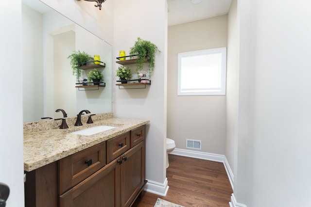 10408 Stoney Point Dr, South Lyon, MI 48178 - half bath featuring wood finished floors, toilet, vanity, and baseboards